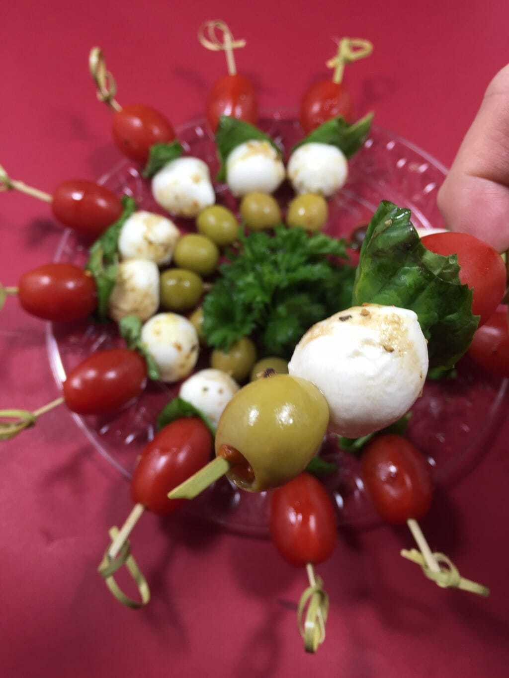 skewered tomatoes, basil, mozzarella cheese and green olive appetizers