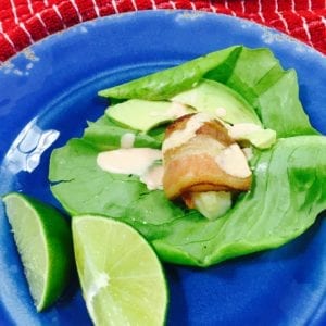 bacon wrapped scallop lettuce wrap on a blue plate