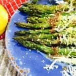 Cooked asparagus with browned butter on a blue plate