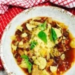 Pork Chile with tortillas and cheese on a white plate