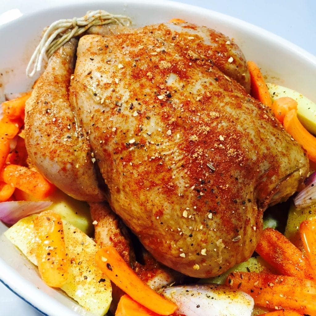 Seasoned Chicken in dish with vegetables ready for roasting