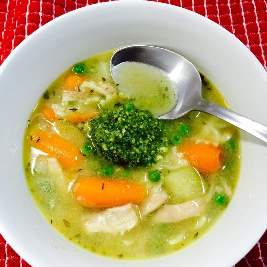 Chicken pesto soup in a white bowl