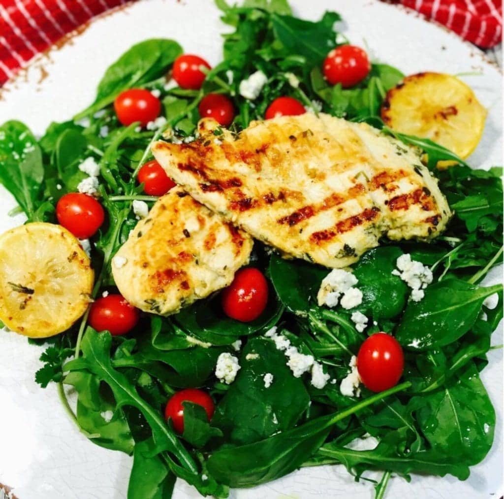Grilled lemon chicken salad on a white plate