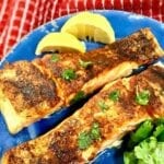baked salmon on a blue plate with lemon