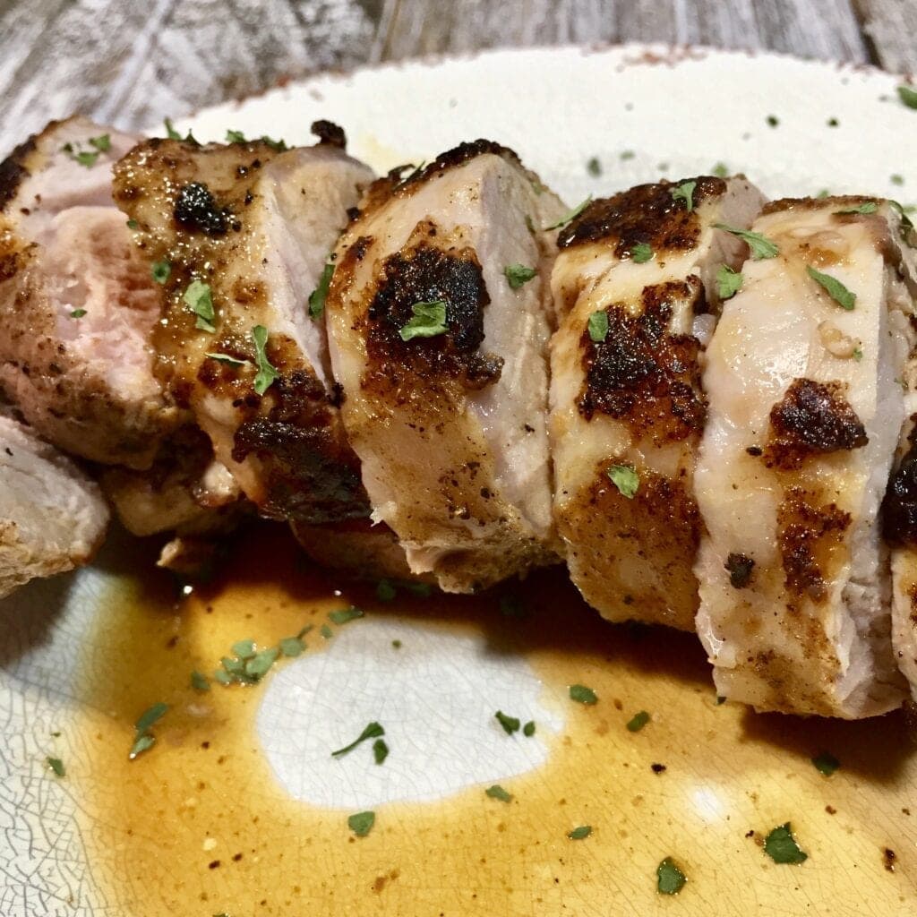 Juicy pork tenderloin on a white plate