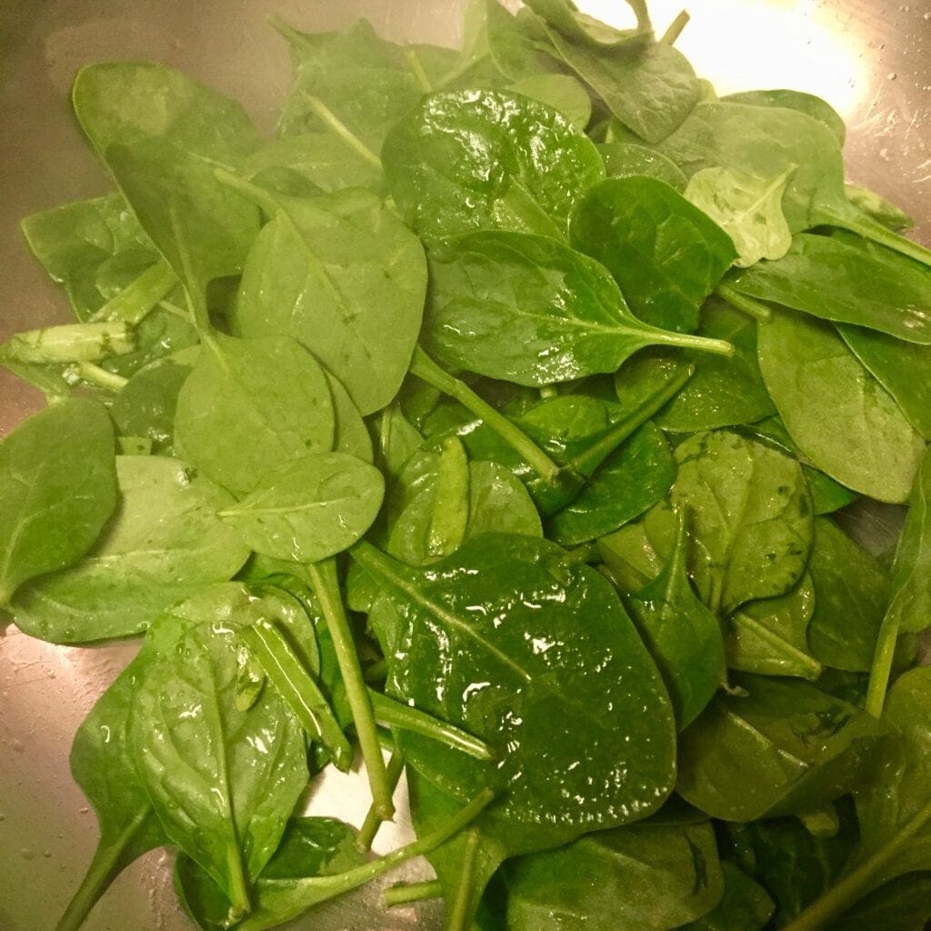 Baby spinach cooking in a frypan