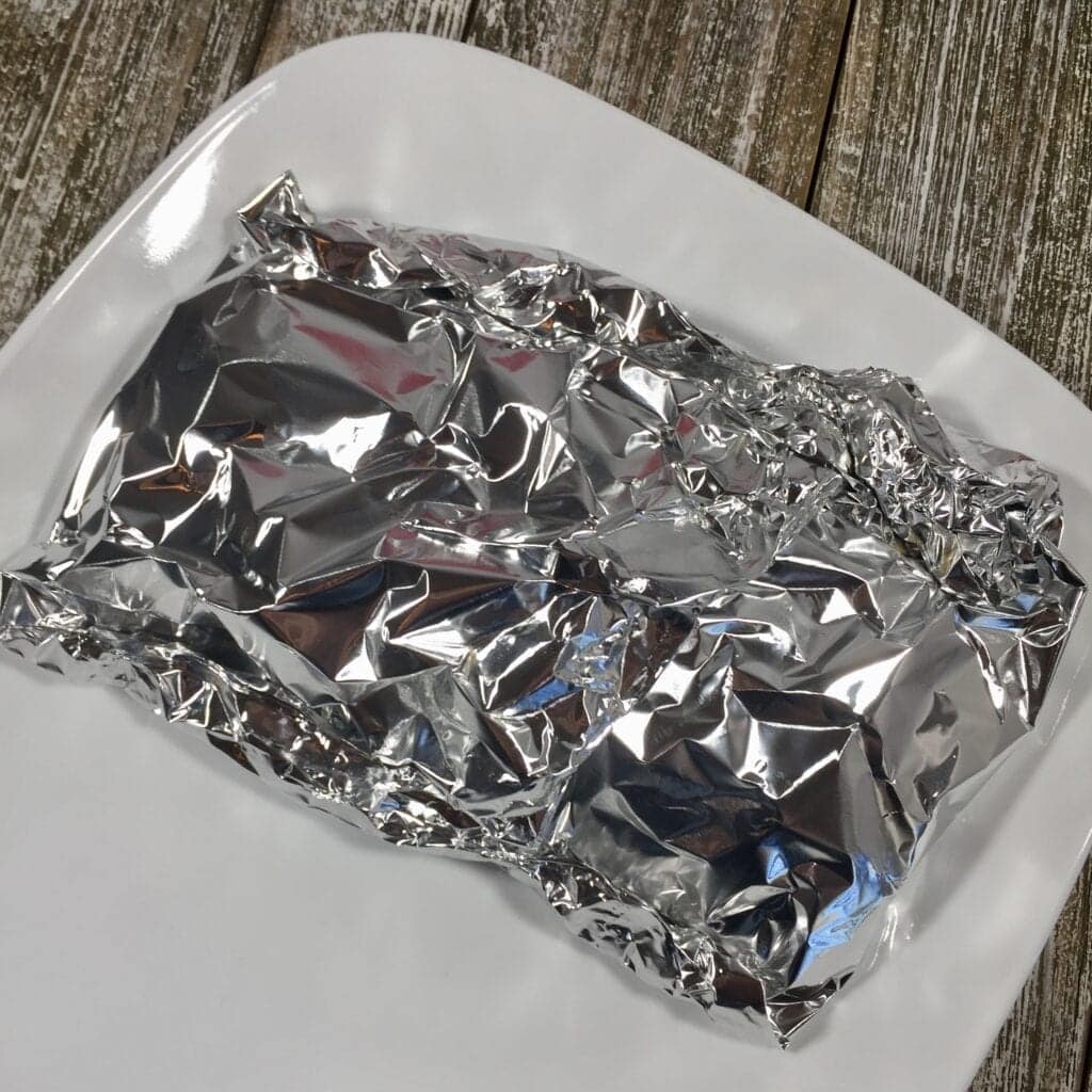 Tin foil package on a white plate