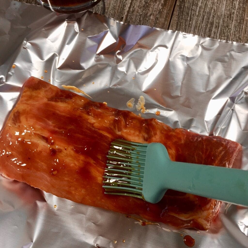 Brushing BBQ sauce on ribs
