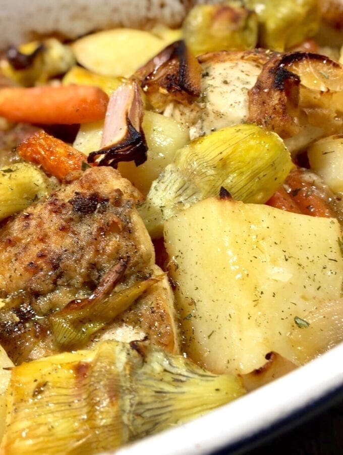 roasted lemon chicken with artichokes, potatoes and carrots in a white pan