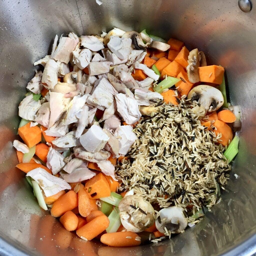 mixed vegetables with diced chicken and wild rice in a saute pan