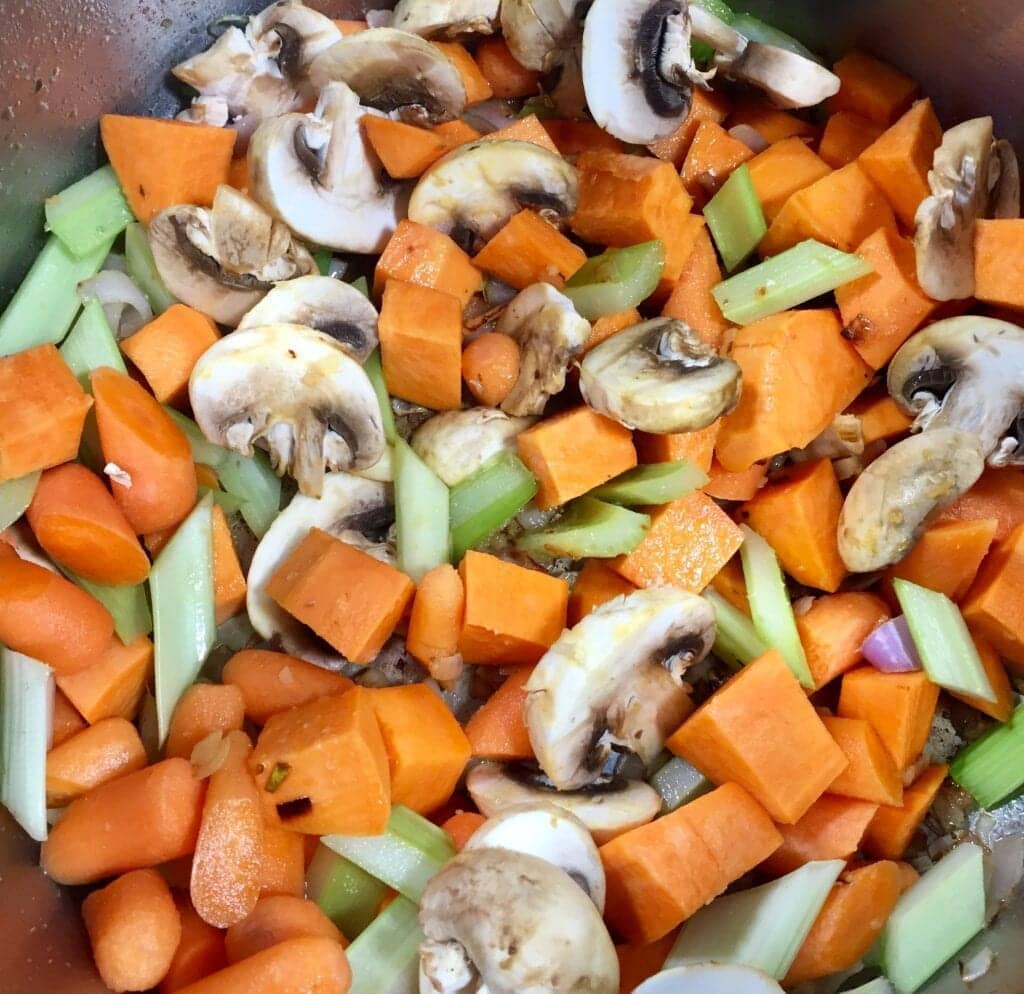 Diced yams, celery, onions and mushrooms cooking in a saute pan