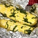 Freshly steamed corn on the cob with fresh basil
