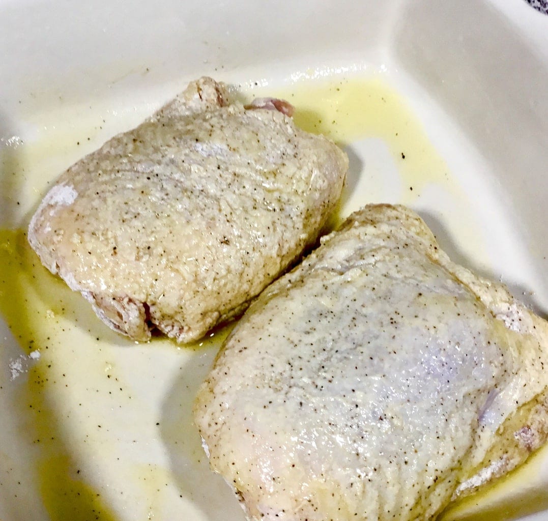 floured and butter dipped chicken in a white pan ready to be baked