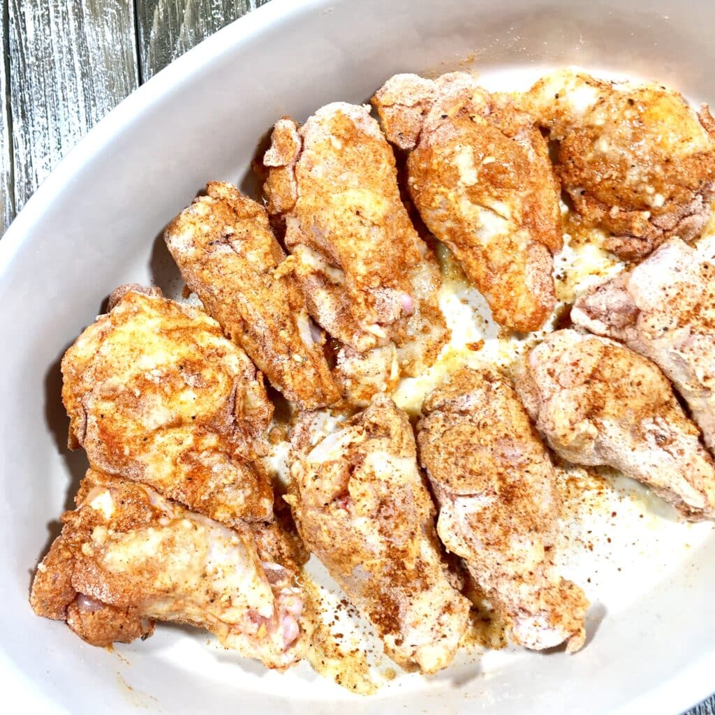 Seasoned chicken wings in a dish ready to be baked