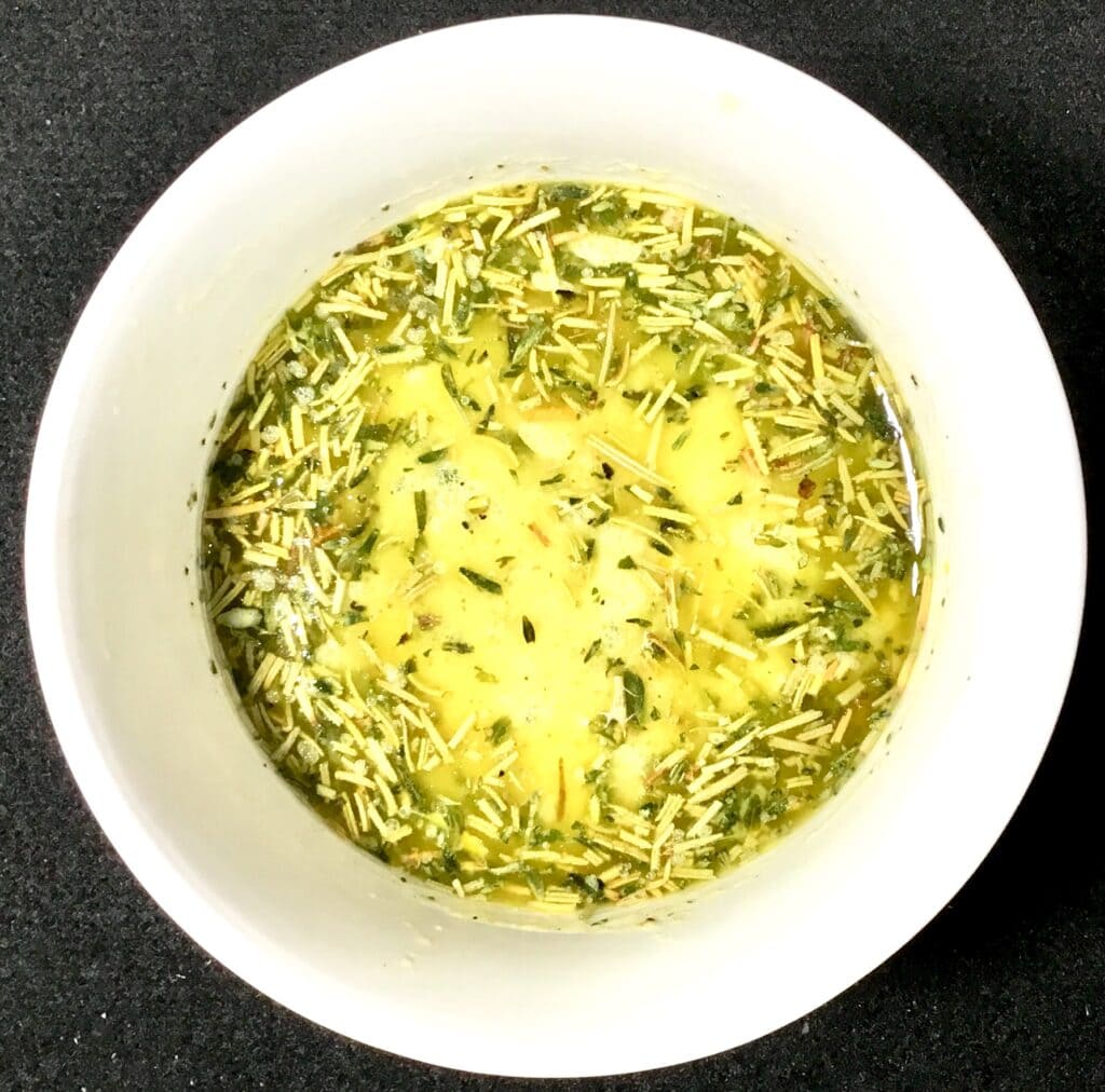 Mustard marinade with herbs in a white bowl