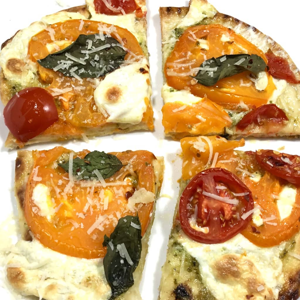 Naan margherita pizza on a white surface