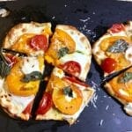 Naan pizza on a black cutting board