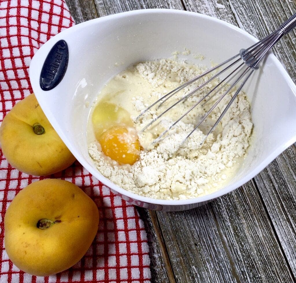 Dry pancake batter in white bowl with an egg