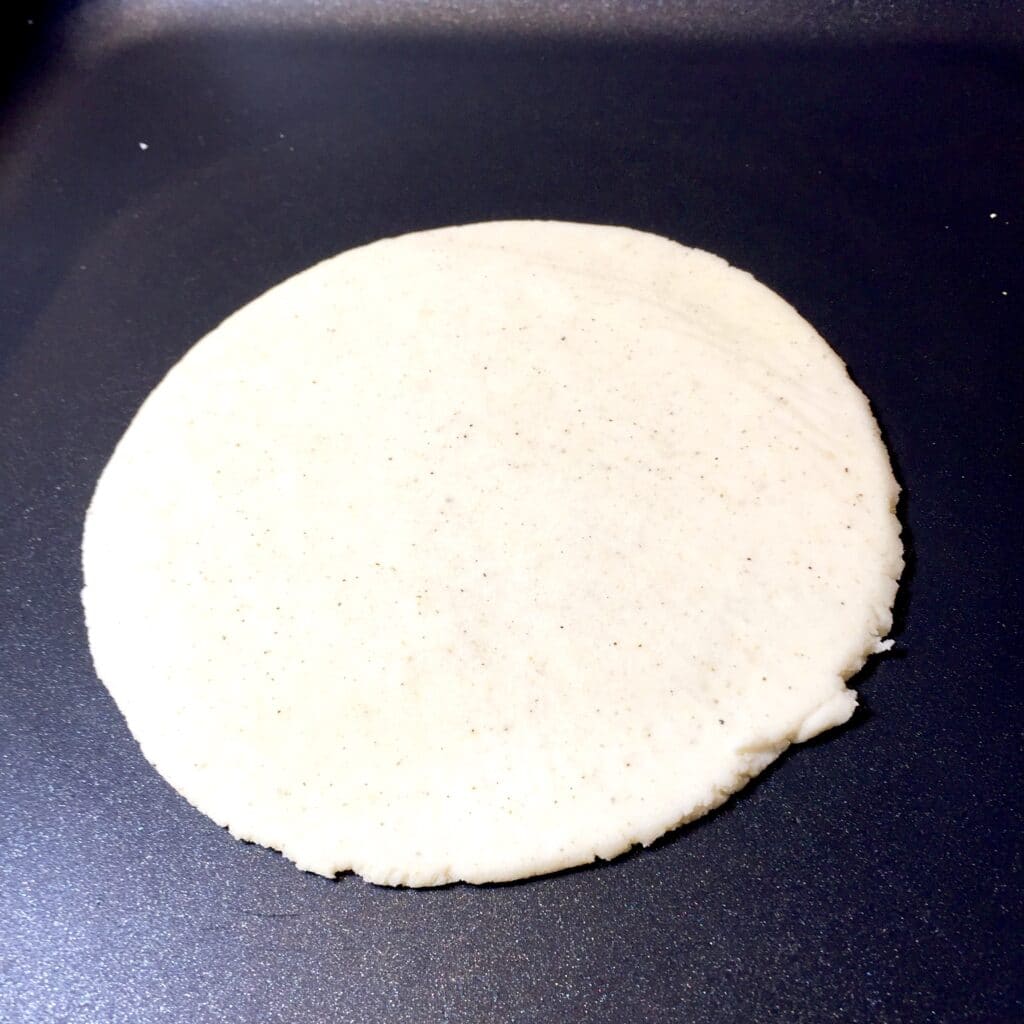 Homemade tortilla cooking on a griddle