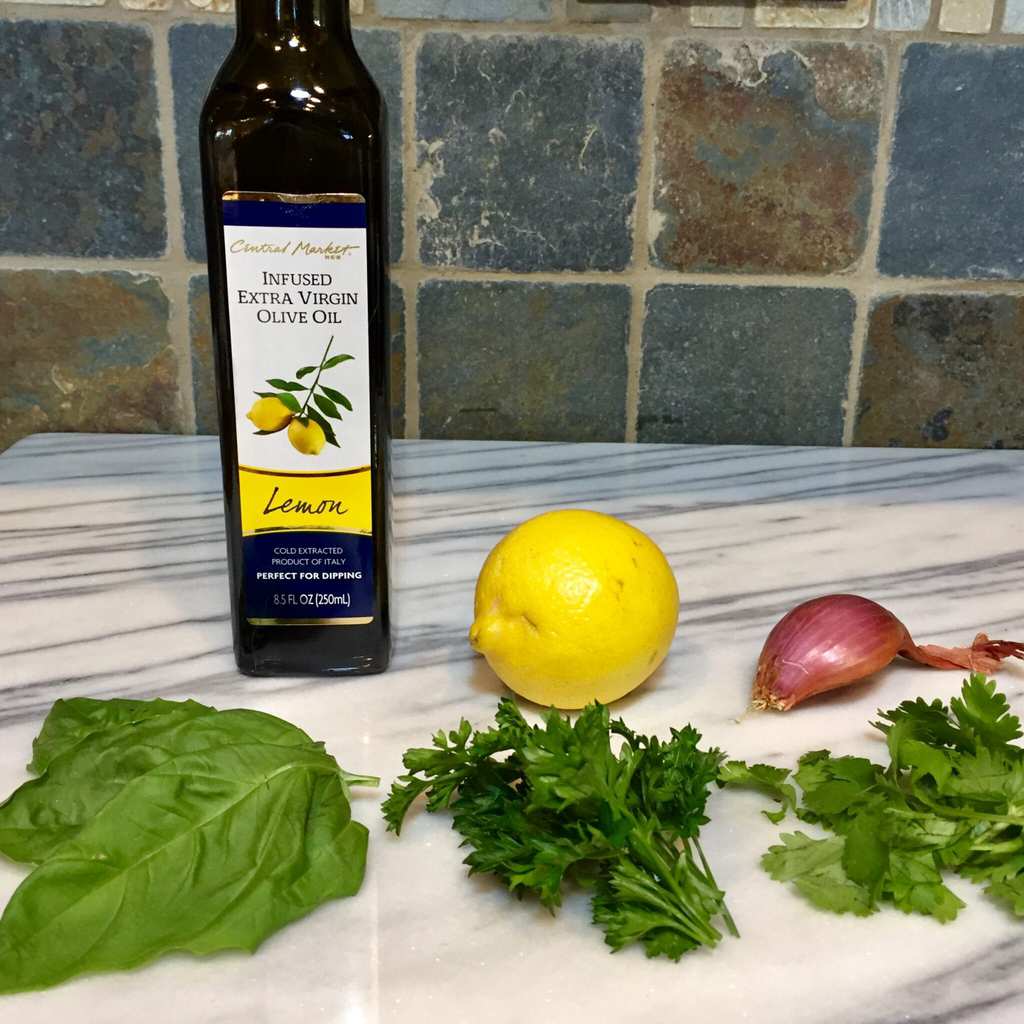 Ingredients for Chimichurri sauce - oil, lemon, parsley, cilantro, basil and shallots
