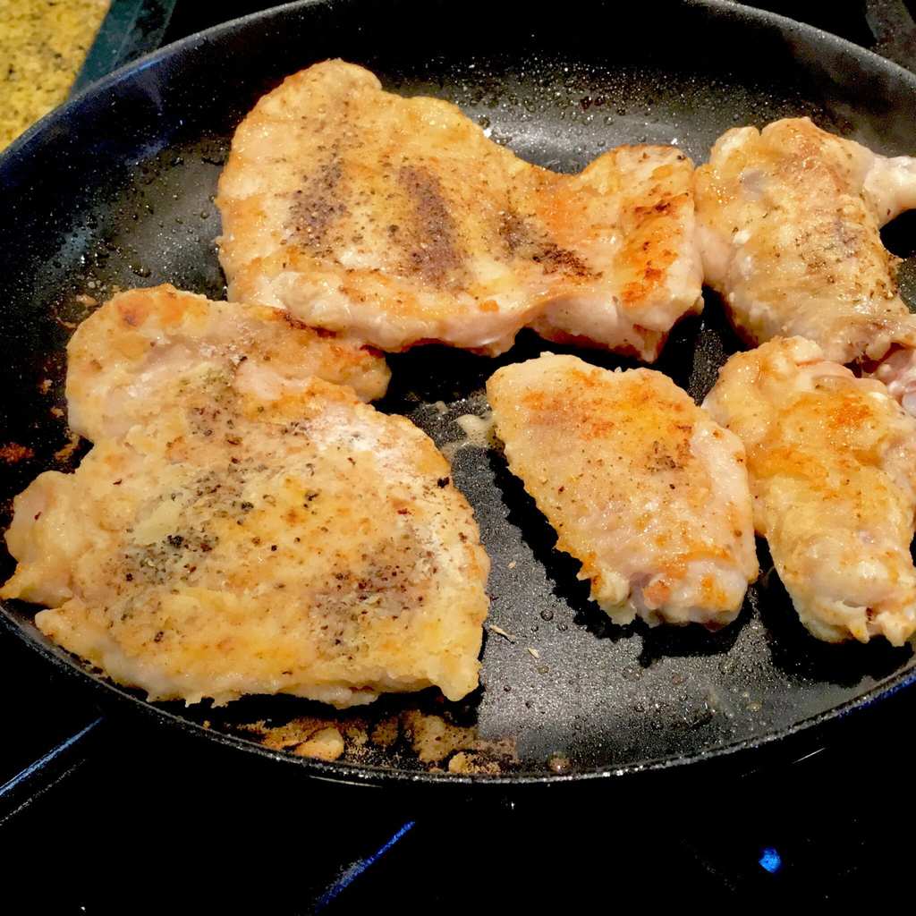 chicken pieces frying in a pan