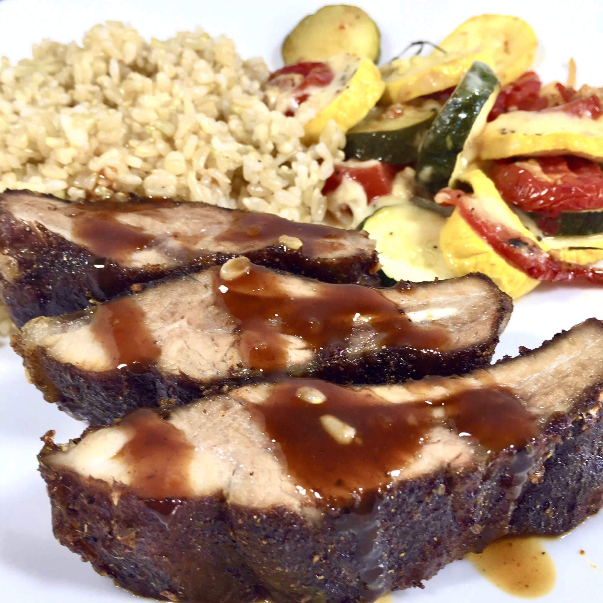 Oven Smoked Dry Ribs with rice and vegetables on a white plate