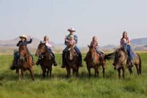 Ranchers on horseback in a grass field